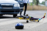 Bicycle accident scene on roadway with car